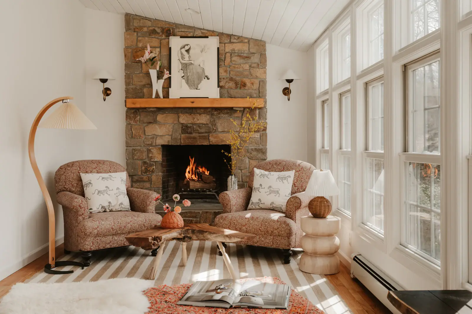 Two armchairs drawn up to a stone fireplace