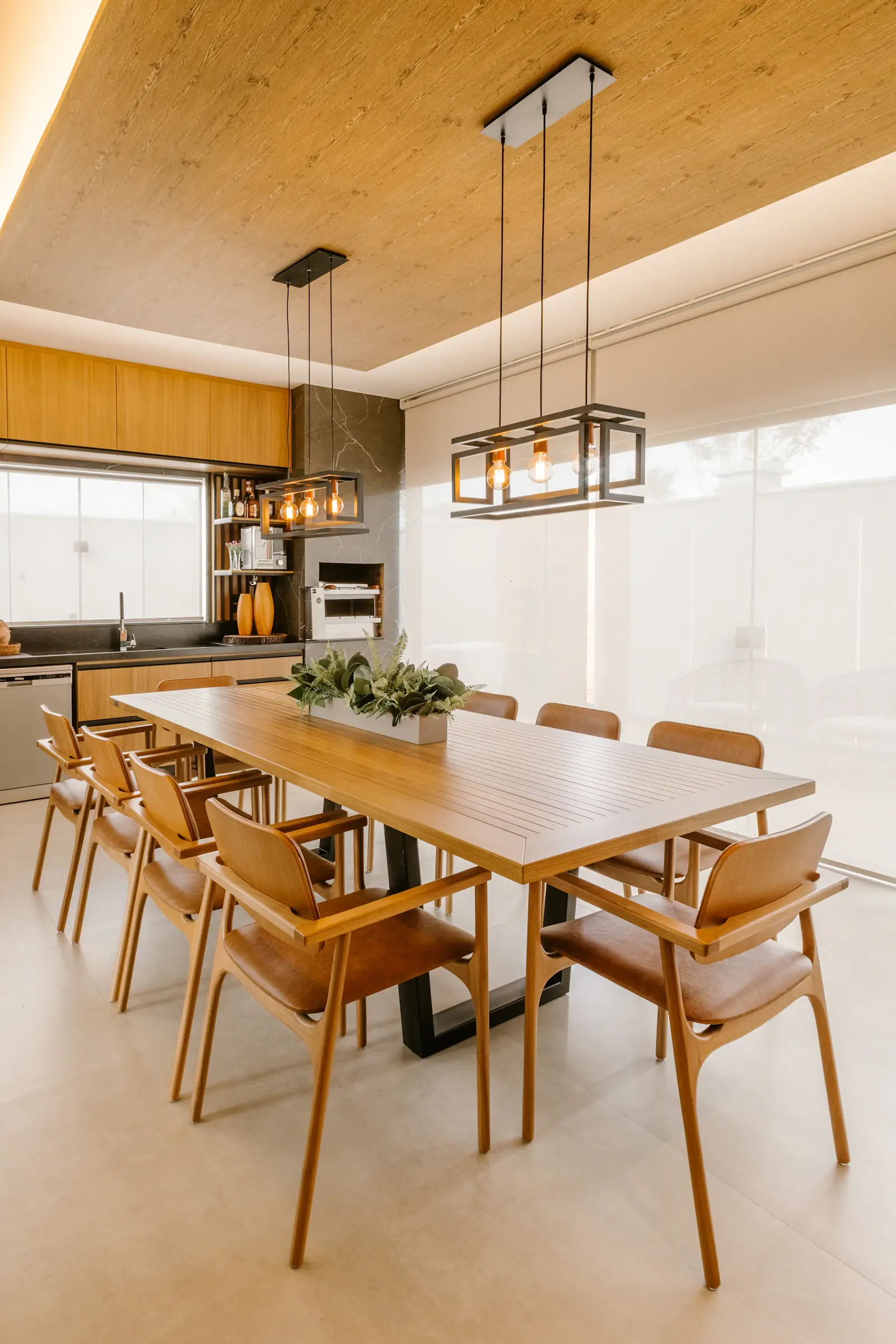 A long oak dining table under rattan pendants