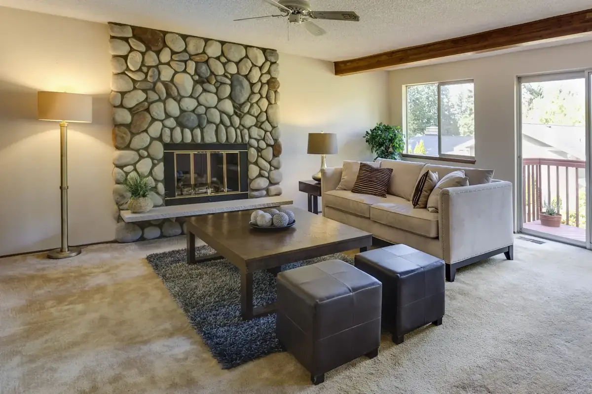 Finished lake-house den with a fieldstone fireplace